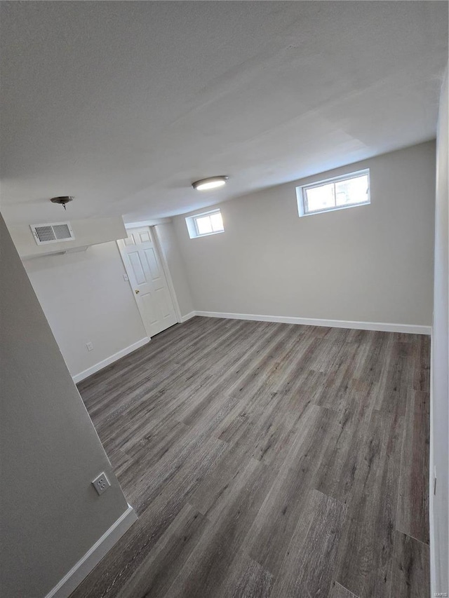 basement with dark hardwood / wood-style flooring