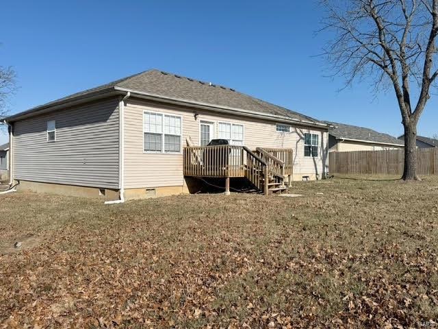 back of house with a wooden deck and a yard