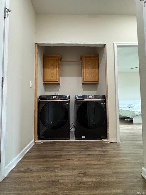 laundry area featuring independent washer and dryer and dark wood-type flooring