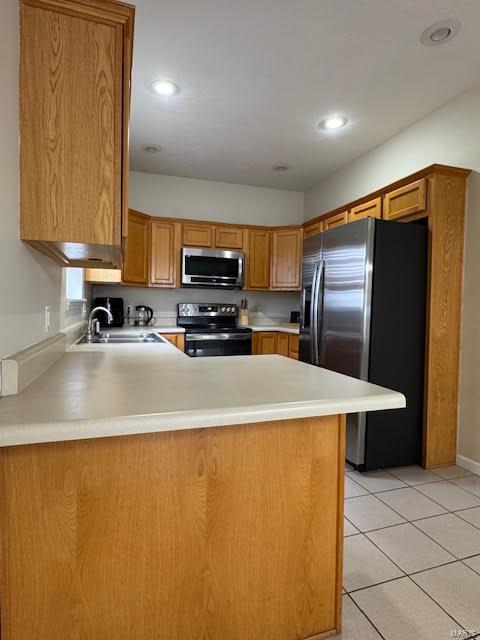 kitchen with sink, stainless steel appliances, kitchen peninsula, and light tile patterned flooring