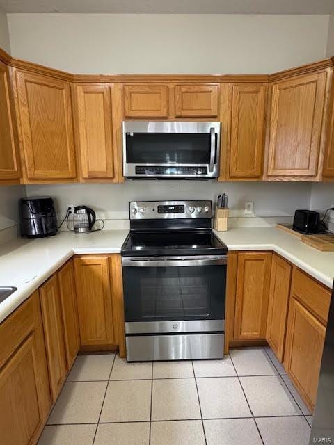 kitchen featuring light tile patterned floors and stainless steel appliances