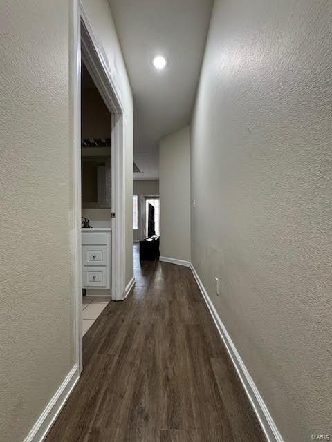 corridor with dark hardwood / wood-style flooring