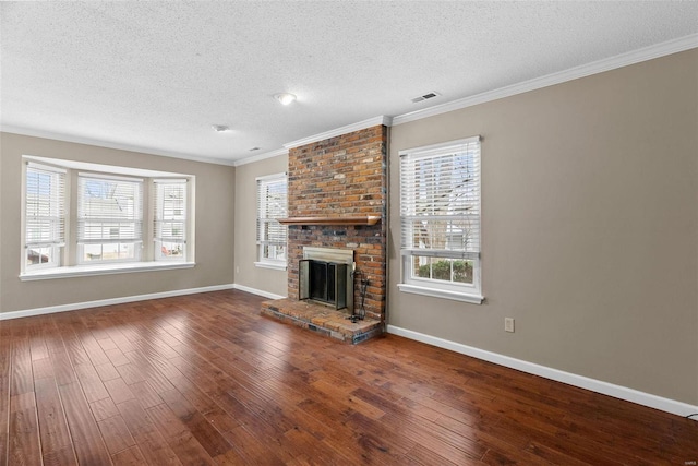 unfurnished living room with crown molding, a brick fireplace, hardwood / wood-style flooring, and a textured ceiling