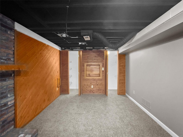 basement featuring carpet floors and wooden walls