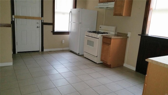 kitchen with white appliances and light tile patterned floors