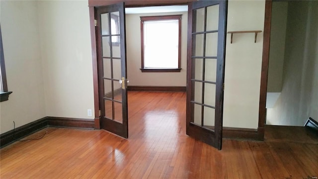 empty room featuring wood-type flooring and french doors