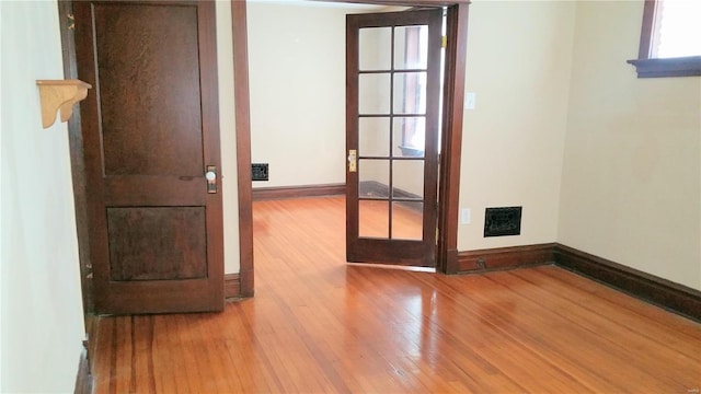 spare room with french doors and light wood-type flooring