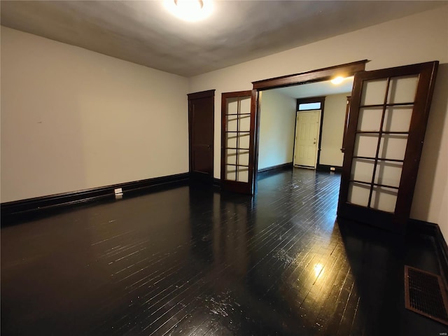 unfurnished room with dark hardwood / wood-style floors and french doors