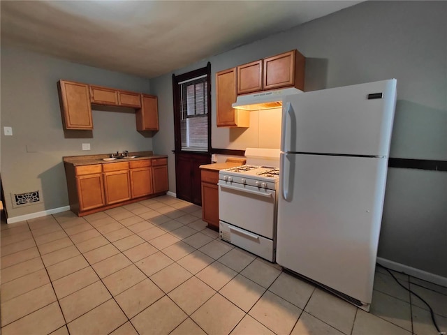 kitchen featuring sink, light tile patterned floors, and white appliances