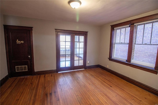 empty room with french doors and light wood-type flooring