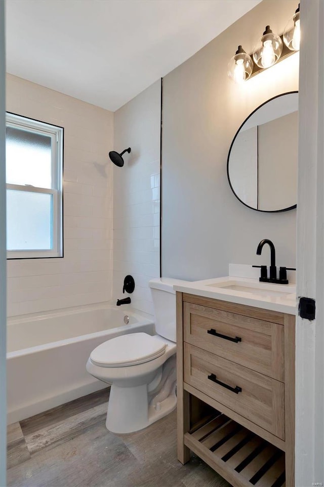 full bathroom with vanity, tiled shower / bath combo, wood-type flooring, and toilet