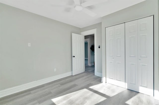 unfurnished bedroom with ceiling fan, light hardwood / wood-style floors, and a closet