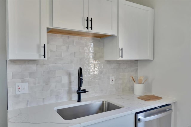 kitchen with sink, light stone counters, dishwasher, decorative backsplash, and white cabinets