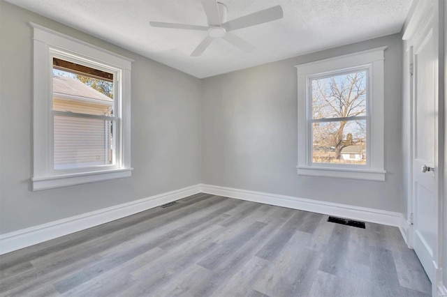 empty room with ceiling fan, a textured ceiling, and light hardwood / wood-style flooring