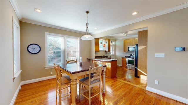 dining area featuring light hardwood / wood-style flooring and ornamental molding