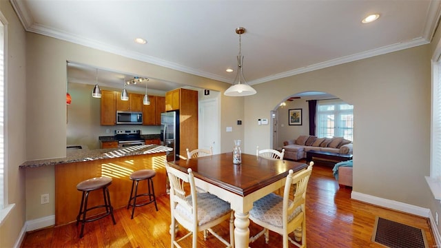 dining room featuring crown molding and light wood-type flooring