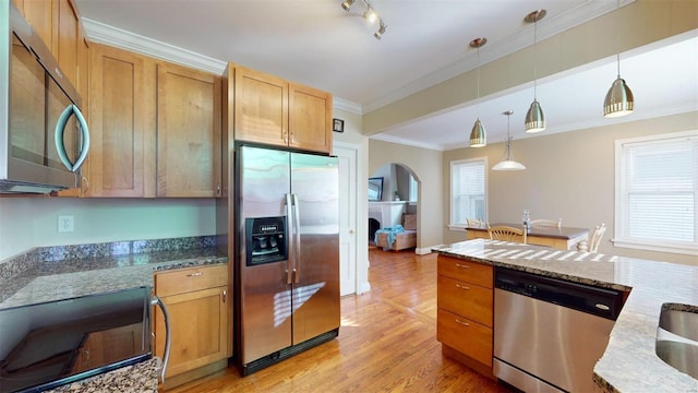 kitchen with pendant lighting, ornamental molding, dark stone counters, and appliances with stainless steel finishes