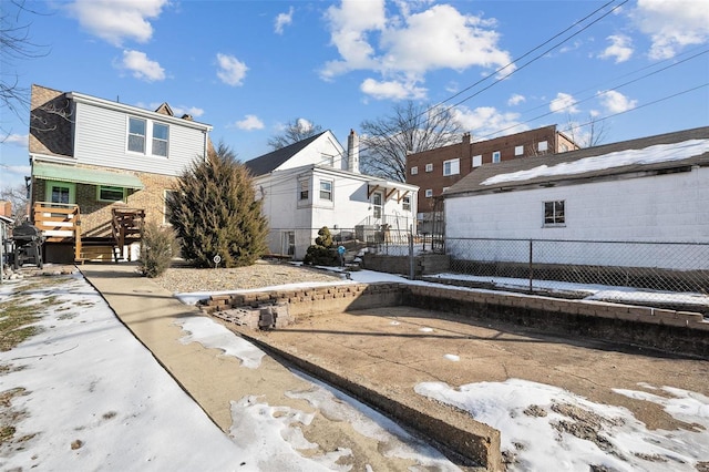 view of snow covered back of property