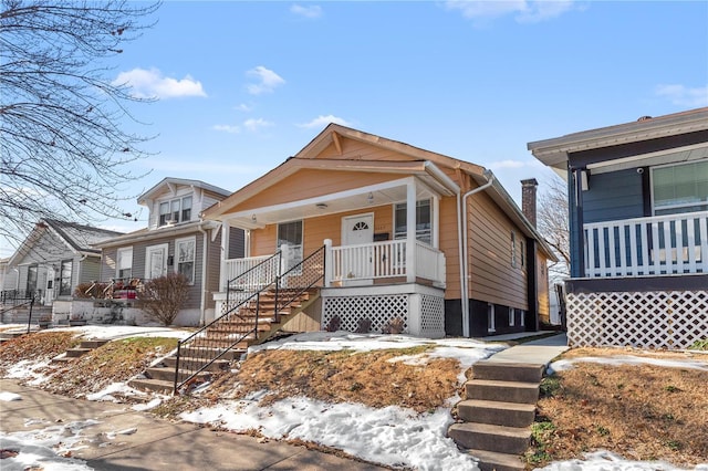 bungalow-style house featuring covered porch and stairway