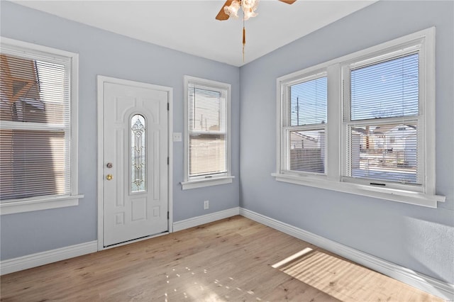 foyer entrance with ceiling fan and light hardwood / wood-style floors