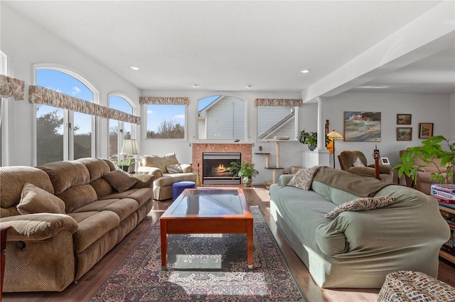 living room featuring a high end fireplace, dark hardwood / wood-style flooring, and ornate columns