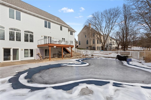 snow covered rear of property featuring a wooden deck