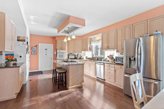 kitchen featuring a center island, hanging light fixtures, dark hardwood / wood-style flooring, a kitchen breakfast bar, and stainless steel appliances