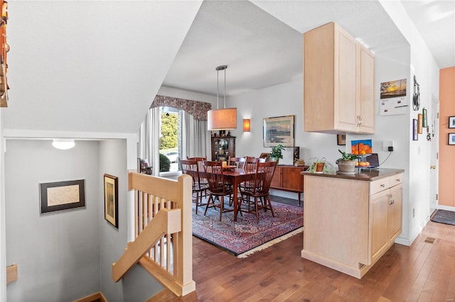 kitchen with wood-type flooring, pendant lighting, and light brown cabinets