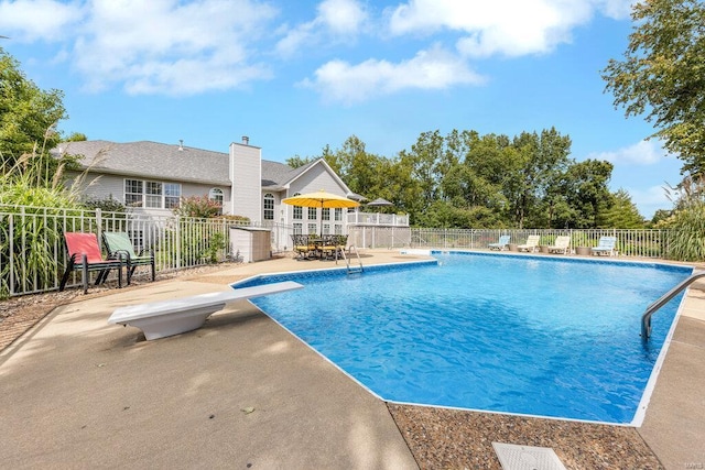 view of pool featuring a patio area and a diving board