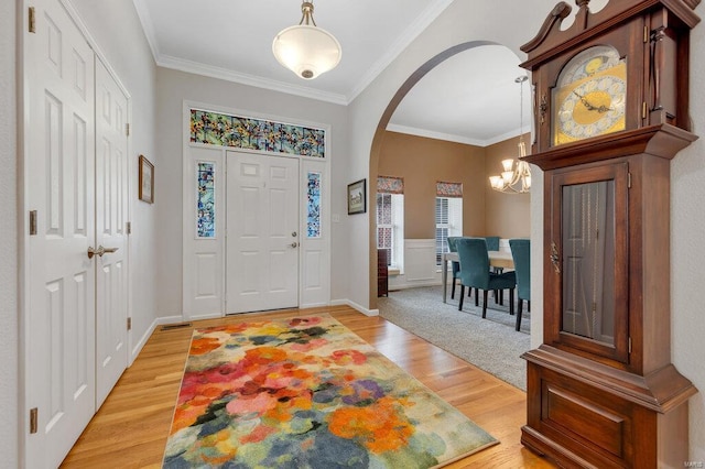 entrance foyer with ornamental molding and hardwood / wood-style floors