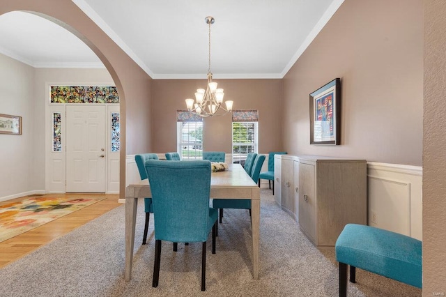 dining space with crown molding, a chandelier, and light wood-type flooring