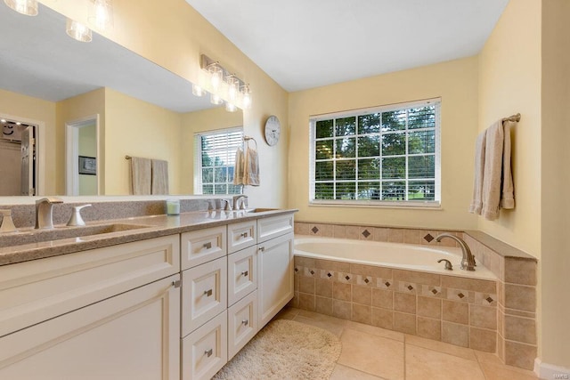 bathroom featuring tile patterned flooring, vanity, and a relaxing tiled tub