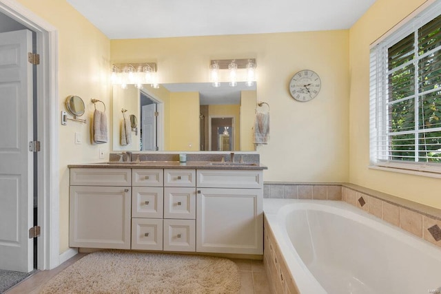 bathroom with vanity, tile patterned floors, and tiled bath