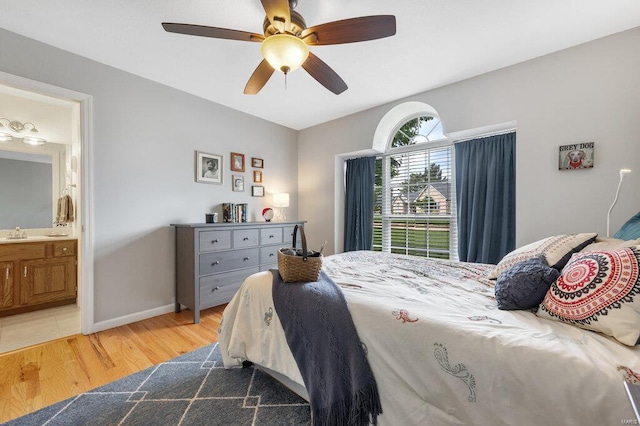 bedroom featuring ensuite bathroom, sink, ceiling fan, and light hardwood / wood-style flooring