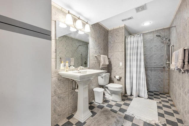 bathroom featuring tile walls, toilet, and walk in shower