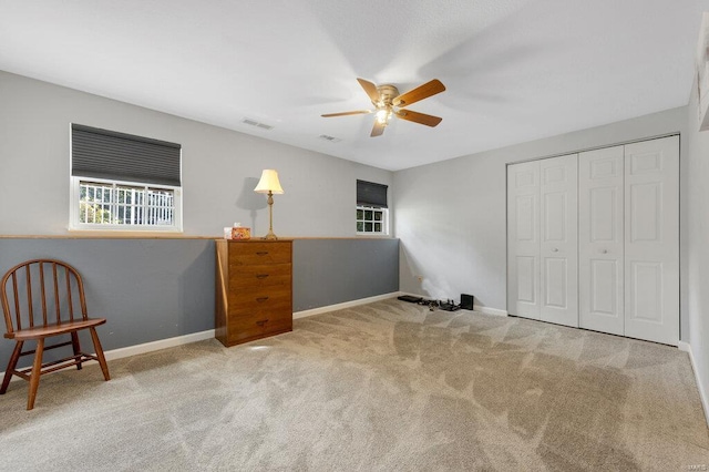 interior space with light carpet, a closet, and ceiling fan