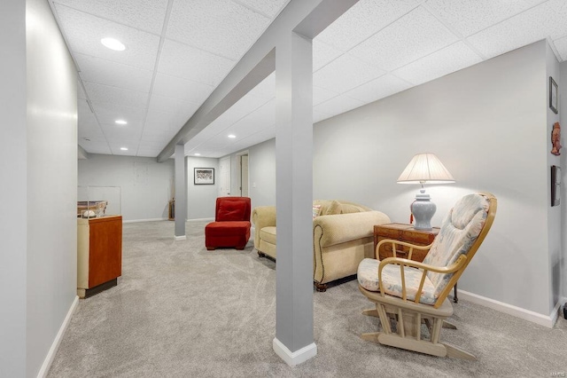 living area featuring light colored carpet and a drop ceiling