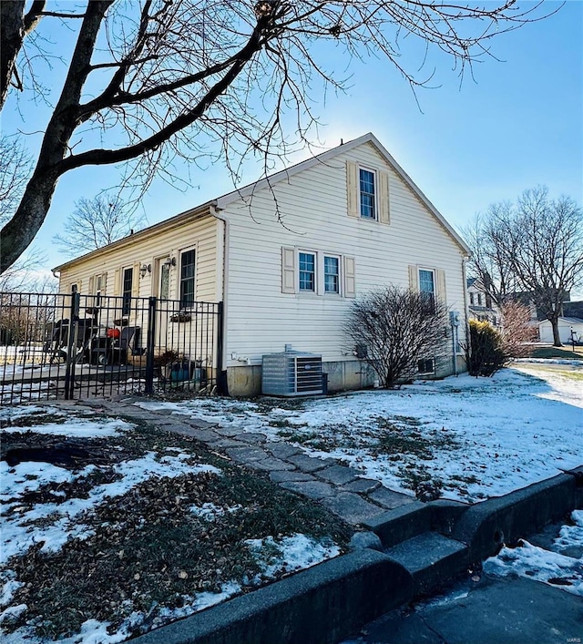 snow covered property featuring central AC unit