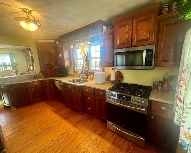 kitchen featuring sink, stainless steel appliances, and light hardwood / wood-style floors