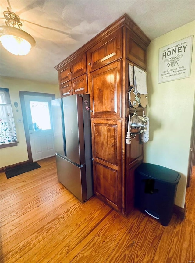 kitchen with stainless steel refrigerator and light hardwood / wood-style flooring