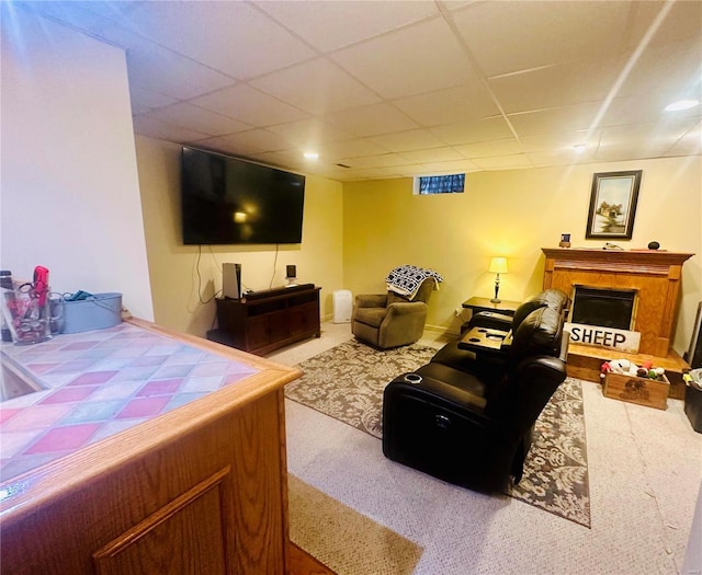 living room featuring a paneled ceiling and carpet