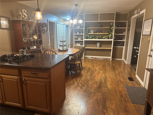 kitchen featuring pendant lighting, dark hardwood / wood-style floors, stainless steel gas cooktop, and an inviting chandelier