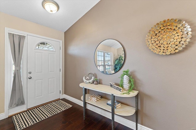 foyer entrance with wood-type flooring and vaulted ceiling