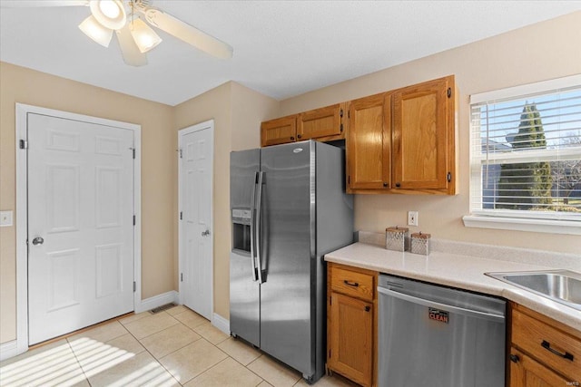 kitchen with ceiling fan, stainless steel appliances, and light tile patterned floors