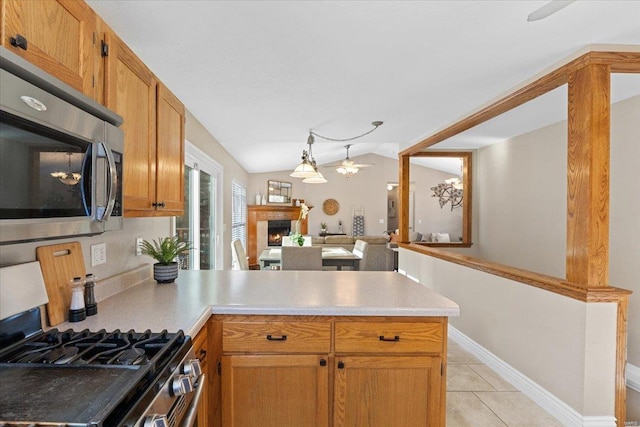 kitchen featuring light tile patterned flooring, lofted ceiling, kitchen peninsula, ceiling fan, and stainless steel appliances