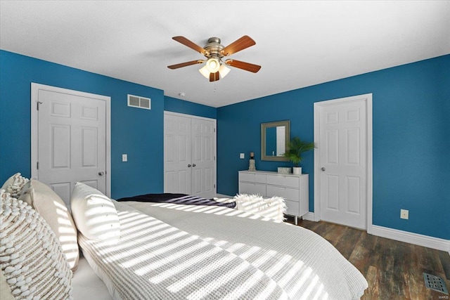 bedroom with dark wood-type flooring, ceiling fan, and a closet