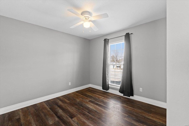 spare room with dark wood-type flooring and ceiling fan