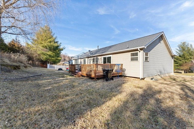 rear view of property featuring a wooden deck and a yard