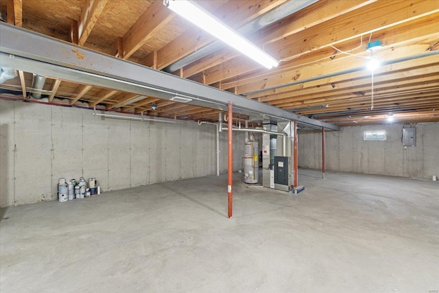 basement featuring gas water heater, heating unit, and electric panel