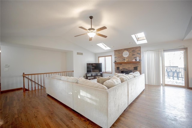 living room featuring hardwood / wood-style floors, a wealth of natural light, and lofted ceiling with skylight